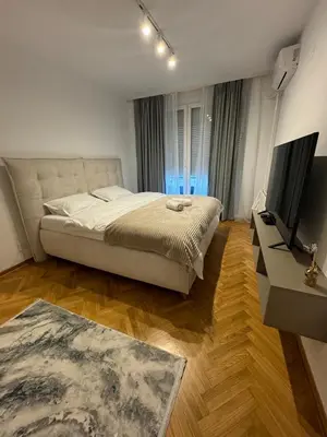 a bedroom with a bed and a flat screen tv at Arena Mila in Novi Beograd