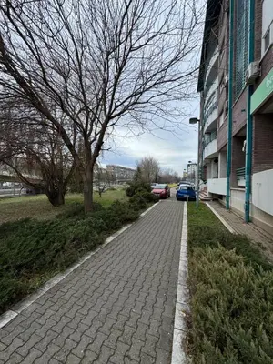 a brick sidewalk next to a building with a tree at Arena Mila in Novi Beograd