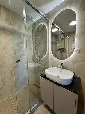 a bathroom with a sink and a shower with a mirror at Arena Mila in Novi Beograd