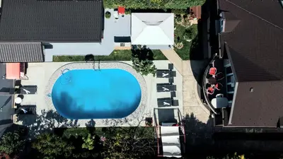 an overhead view of a swimming pool with parked cars at Lux Apartments With Pool Dex in Zemun Polje