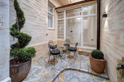a patio with chairs and a table and a window at Apartment Kaliopi in Belgrade