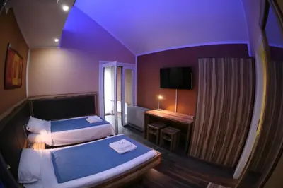 a room with two beds and a desk with a television at Apartments 43 in Krnjača