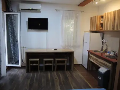 a small kitchen with a table and a refrigerator at Apartments 43 in Krnjača