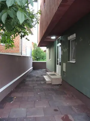 an empty hallway of a green building with a door at Apartments 43 in Krnjača