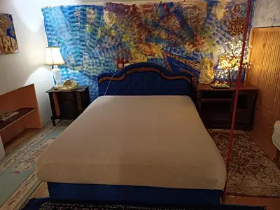 a bedroom with a blue bed and a mosaic wall at Maravilja 7 in Belgrade