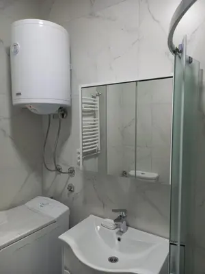 a white bathroom with a sink and a mirror at Nikola Hram in Belgrade