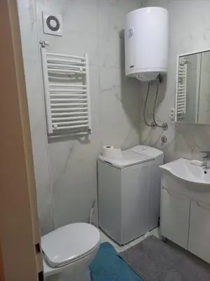 a white bathroom with a toilet and a sink at Nikola Hram in Belgrade