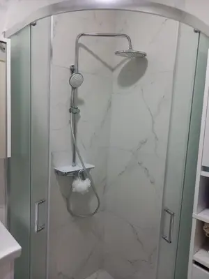 a shower in a bathroom with white marble at Nikola Hram in Belgrade
