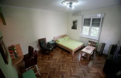 a room with a bed and a table and a window at Studio Tash in Belgrade
