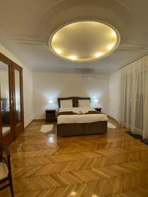 a bedroom with a bed and a large ceiling at Apartment Washington in Belgrade