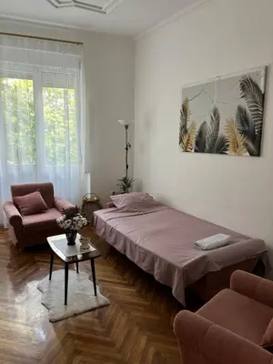 a room with two beds and a couch and a table at Apartment Washington in Belgrade