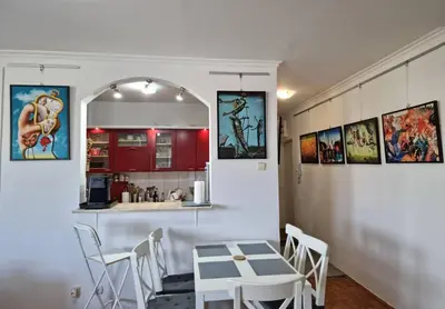a kitchen with a table and chairs in a room at Dali Arena Business Comfort Apartment 2 Bedrooms King Size in Belgrade
