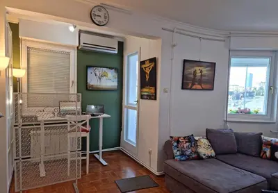 a living room with a couch and a bird cage at Dali Arena Business Comfort Apartment 2 Bedrooms King Size in Belgrade