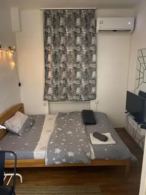 a bedroom with a bed and a curtain and a television at Shine DISCO room in Belgrade