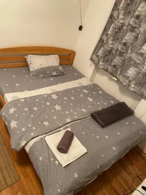 a bedroom with a bed with a gray comforter and a towel at Shine DISCO room in Belgrade