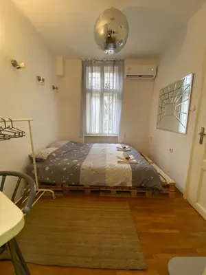 a bedroom with a bed in a room with a window at Shine DISCO room in Belgrade