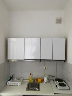 a kitchen with white cabinets and a sink at Shine DISCO room in Belgrade