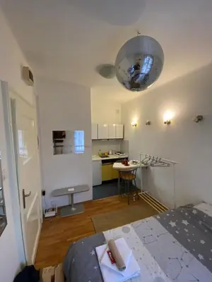 a room with a bed and a kitchen with a table at Shine DISCO room in Belgrade