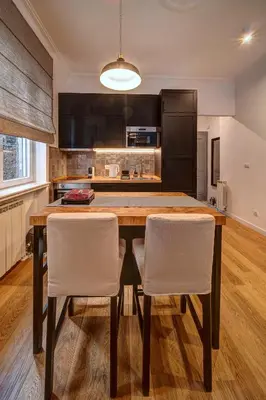 a kitchen with a wooden table and white chairs at Miss Sunshine 4* in Belgrade