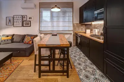 a kitchen and living room with a table and a couch at Miss Sunshine 4* in Belgrade