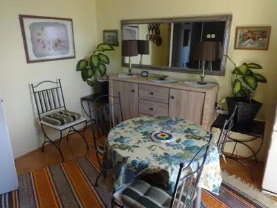 a dining room with a table and a mirror at Apartment Baroque in Belgrade