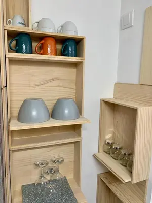 a kitchen with wooden shelves with cups and bowls at Gallery in Belgrade