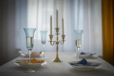 a table with glasses and plates and candles on it at Tera apartment Zemun in Belgrade