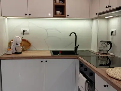 a kitchen with white cabinets and a sink at Tera apartment Zemun in Belgrade