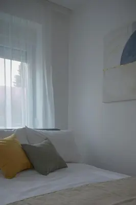 a white bed with two pillows and a window at Tera apartment Zemun in Belgrade