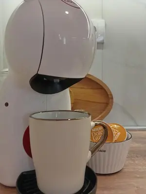 a coffee maker is pouring coffee into a cup at Tera apartment Zemun in Belgrade