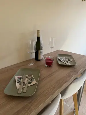 a wooden table with a bottle of wine and glasses at My Pier in Bele Vode
