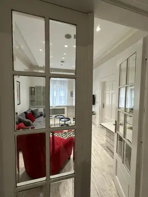 a living room with a red couch and a kitchen at Sofi1 in Belgrade