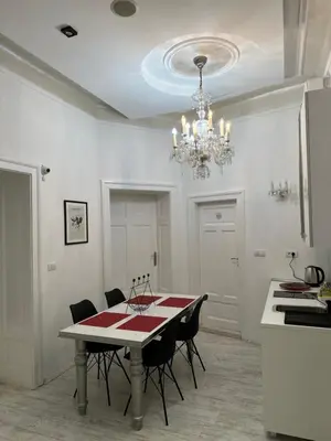 a dining room with a table with chairs and a chandelier at Sofi1 in Belgrade