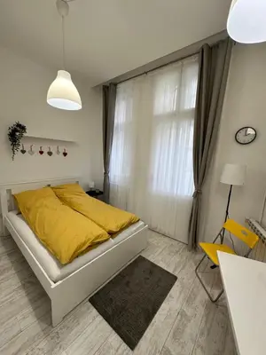 a bedroom with a bed with yellow sheets and a window at Sofi 2 in Belgrade