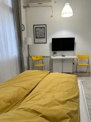 a bedroom with a yellow bed and a television at Sofi 2 in Belgrade