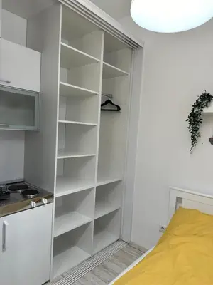 a white book shelf in a room with a bed at Sofi 2 in Belgrade