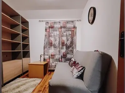 a living room with a couch and a clock at Stan na dan BALANS in Ledine