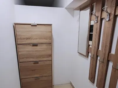 a bathroom with a closet with wooden drawers and a mirror at Stan na dan BALANS in Ledine