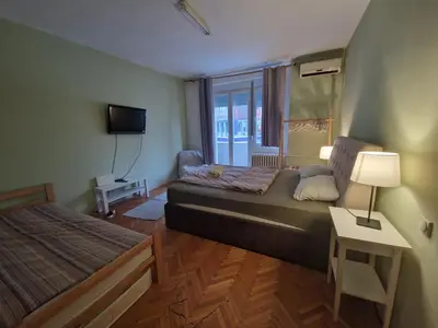 a small room with two beds and a window at Central Station Private Rooms in Belgrade