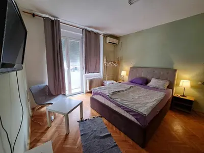 a bedroom with a bed and a tv in it at Central Station Private Rooms in Belgrade