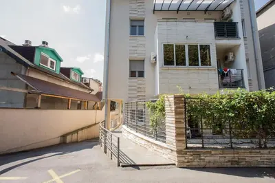 a house with a fence in front of a building at Studio apartment Duda in Karaburma