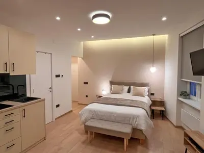 a bedroom with a large bed and a kitchen at Terazije Center Apartments in Belgrade