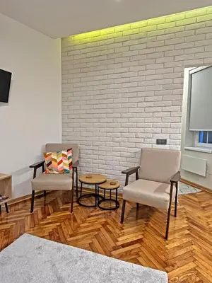 a living room with two chairs and a tv at Terazije Center Apartments in Belgrade