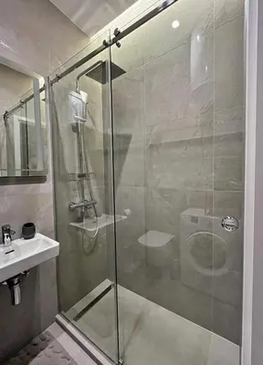 a shower with a glass door next to a sink at Terazije Center Apartments in Belgrade