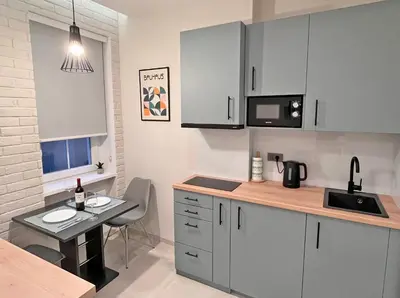 a kitchen with white cabinets and a table with a bottle of wine at Terazije Center Apartments in Belgrade