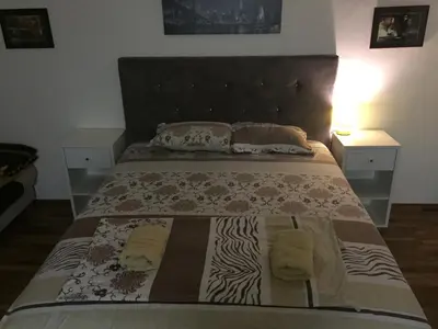 a bedroom with a large bed with two night stands at Apartman Birboni Pul ZEMUN in Tošin Bunar