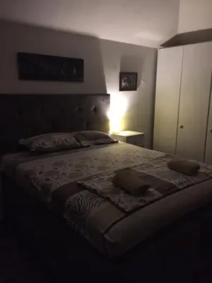 a bedroom with a large bed with a night stand at Apartman Birboni Pul ZEMUN in Tošin Bunar