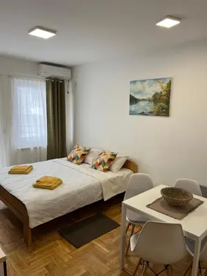 a bedroom with a bed and a table with chairs at App Titan in Stara Pazova