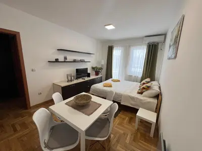 a small room with a bed and a table and chairs at App Titan in Stara Pazova