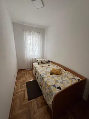 a small bedroom with a bed in the corner of a room at App Titan in Stara Pazova